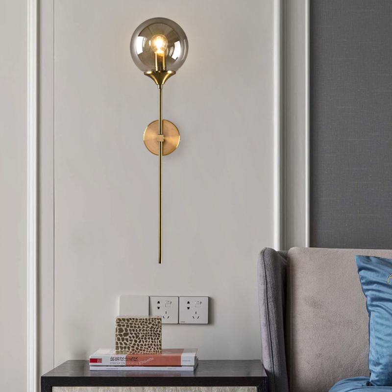 Lámpara de pared design con brazo dorado y bola de cristal