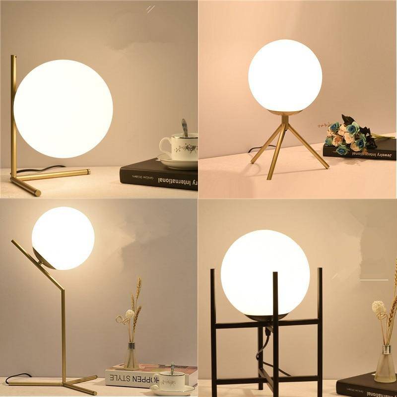 Design table lamp with golden arms and glass ball