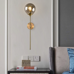 Applique murale design à LED avec bras doré et boule en verre