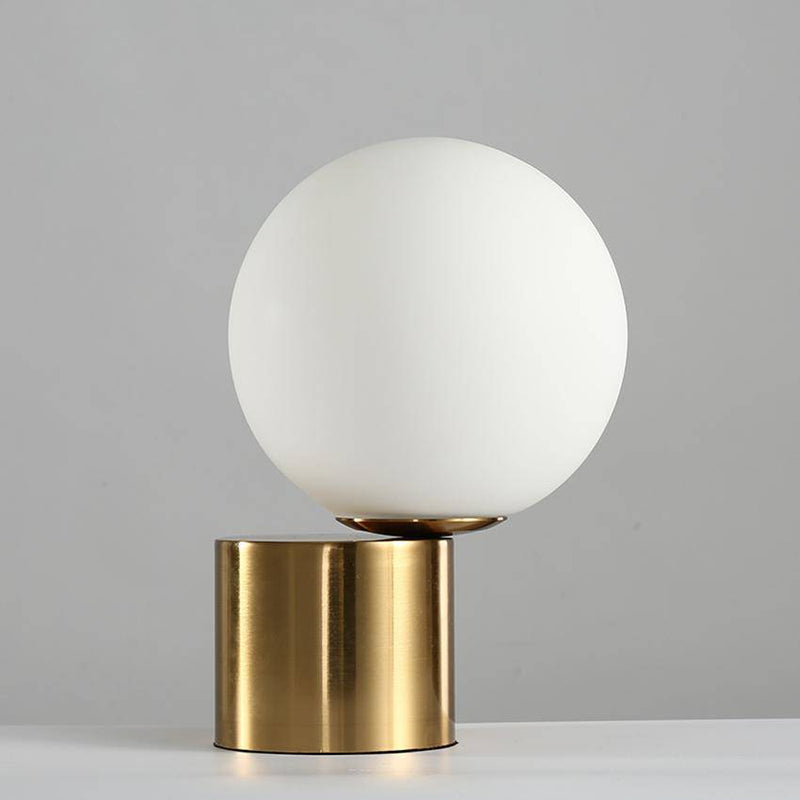 Bedside lamp with gold base and modern glass ball