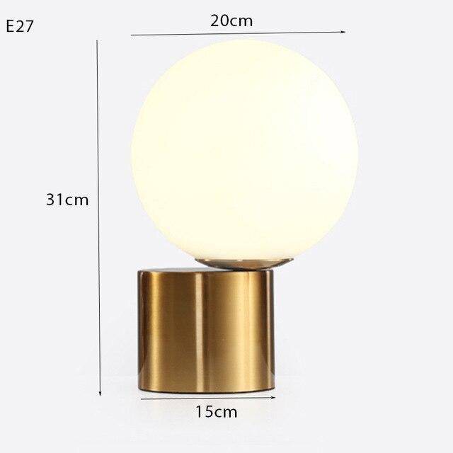 Bedside lamp with gold base and modern glass ball