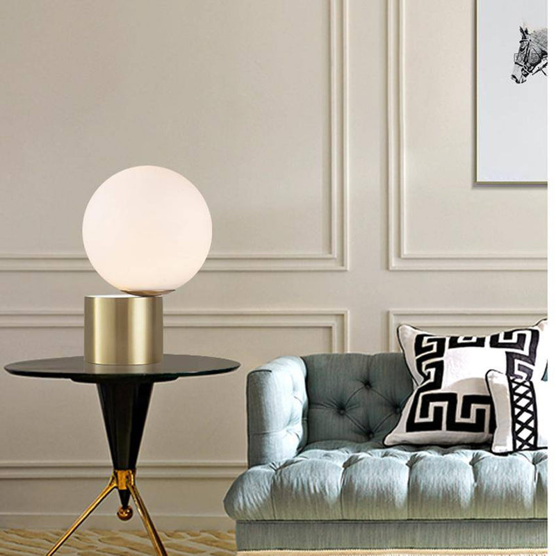 Bedside lamp with gold base and modern glass ball