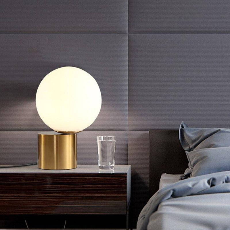 Bedside lamp with gold base and modern glass ball