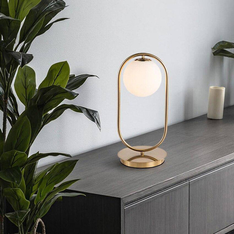 Design bedside lamp in gilded metal and glass ball