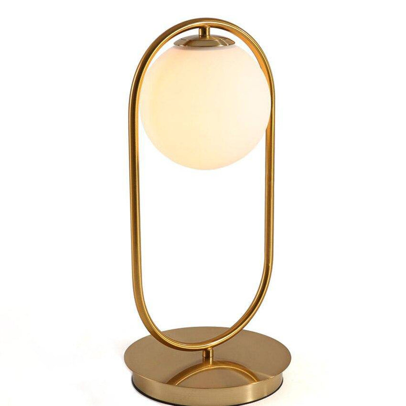 Design bedside lamp in gilded metal and glass ball