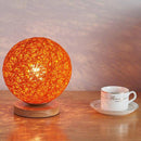 Lampe à poser LED avec socle bois et boule en tissu de couleur Wicker