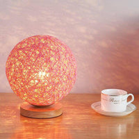 Lampe à poser LED avec socle bois et boule en tissu de couleur Wicker