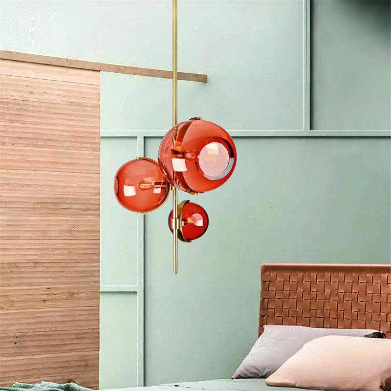 Suspension design LED avec tige doré et trois boules en verre rouge