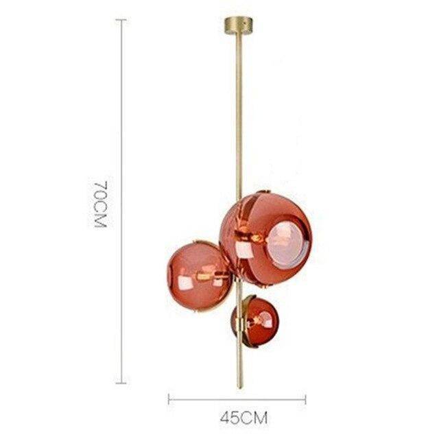 Suspension design LED avec tige doré et trois boules en verre rouge