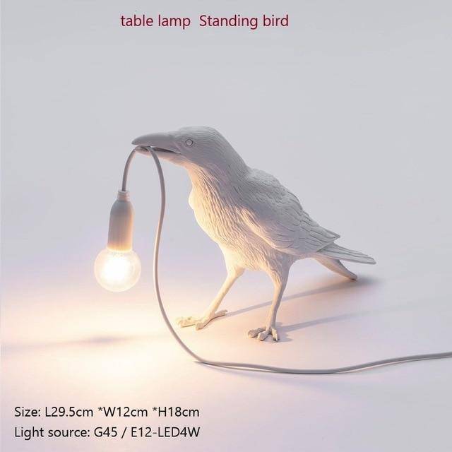 Aplique LED con un pájaro que sostiene una lámpara en el pico