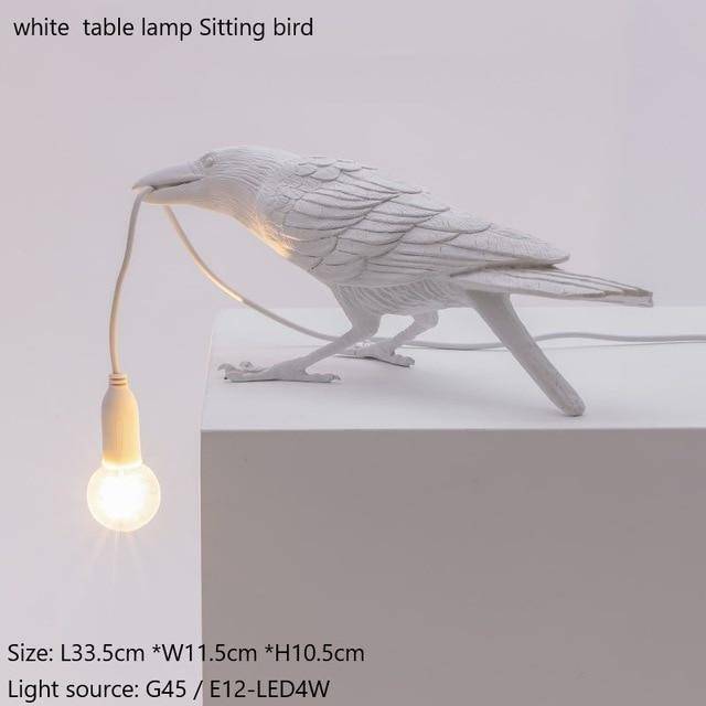Aplique LED con un pájaro que sostiene una lámpara en el pico