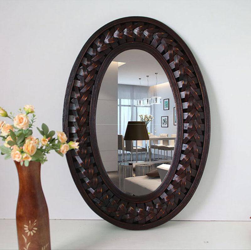 Decorative oval wall mirror in dark woven wood