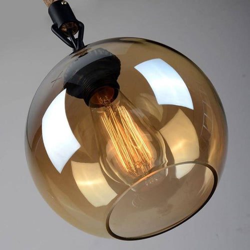 Suspension design boule en verre ambré sur corde Decor
