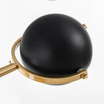 Lampadaire design doré avec abat-jour boule noire et base en marbre