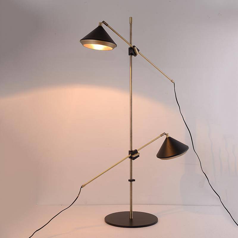 Lámpara de pie design con dos pantallas ajustables sobre una base dorada Sofá