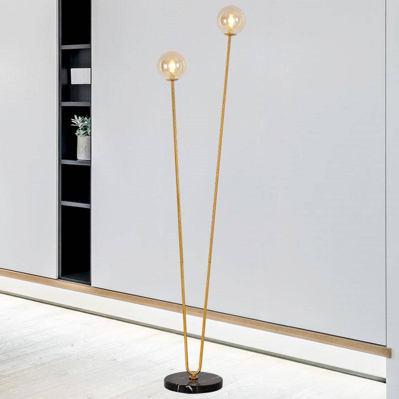 Lampadaire design avec deux branches doré et boules en verre