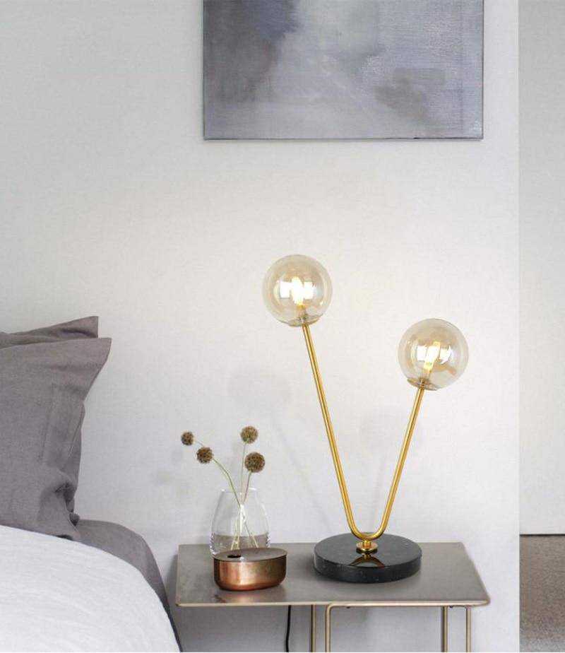 Design bedside lamp with two golden branches and glass balls