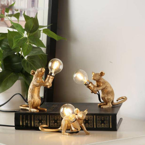 Table lamp in the shape of a mouse holding a lamp